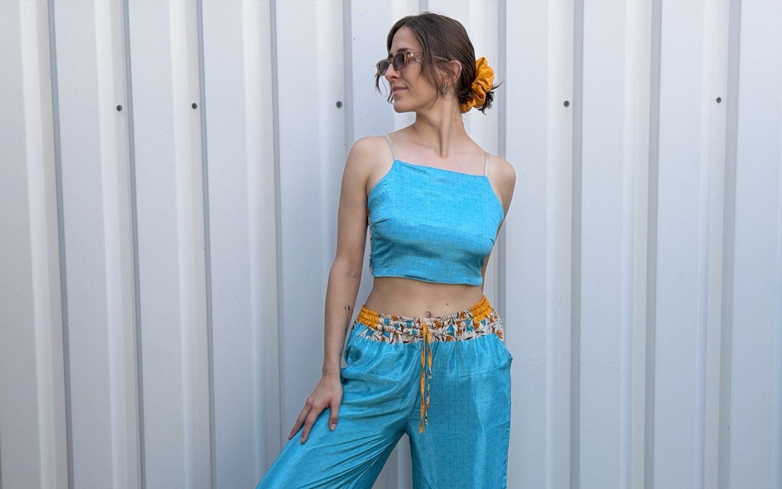 Model trägt Zweiteiler-Set aus hellblauer Sari: Crop Top und Palazzo-Hose mit gelb geblümtem Bund