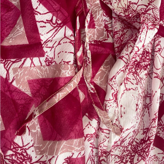 Stoffdetail: upcycelter Sari-Stoff in Beerenrot und Weiß mit geometrischem Muster und Zweig-Print