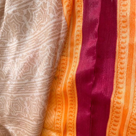 Stoffdetail: upcycelter Sari-Stoff in Creme und Orange mit Bordüren-Print und Magenta-Akzent