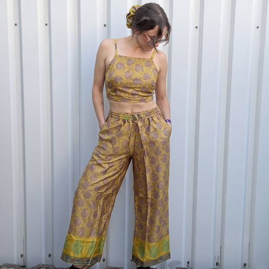 Model trägt Upcycled Set aus Wickeltop und Palazzo-Hose aus Sari-Stoff in Gelb