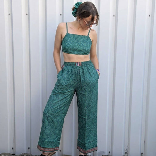 Model trägt Upcycled Set aus Wickeltop und Palazzo-Hose aus Sari-Stoff in Grün