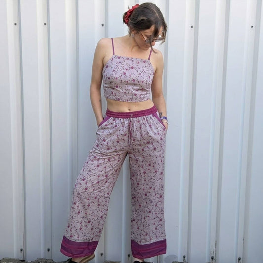 Model trägt Upcycled Set aus Wickeltop und Palazzo-Hose aus Sari-Stoff in Rosa