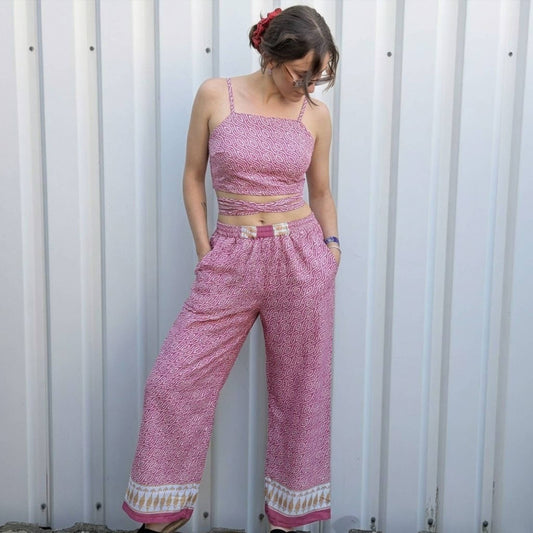 Model trägt Upcycled Set aus Wickeltop und Palazzo-Hose aus Sari-Stoff in Pink