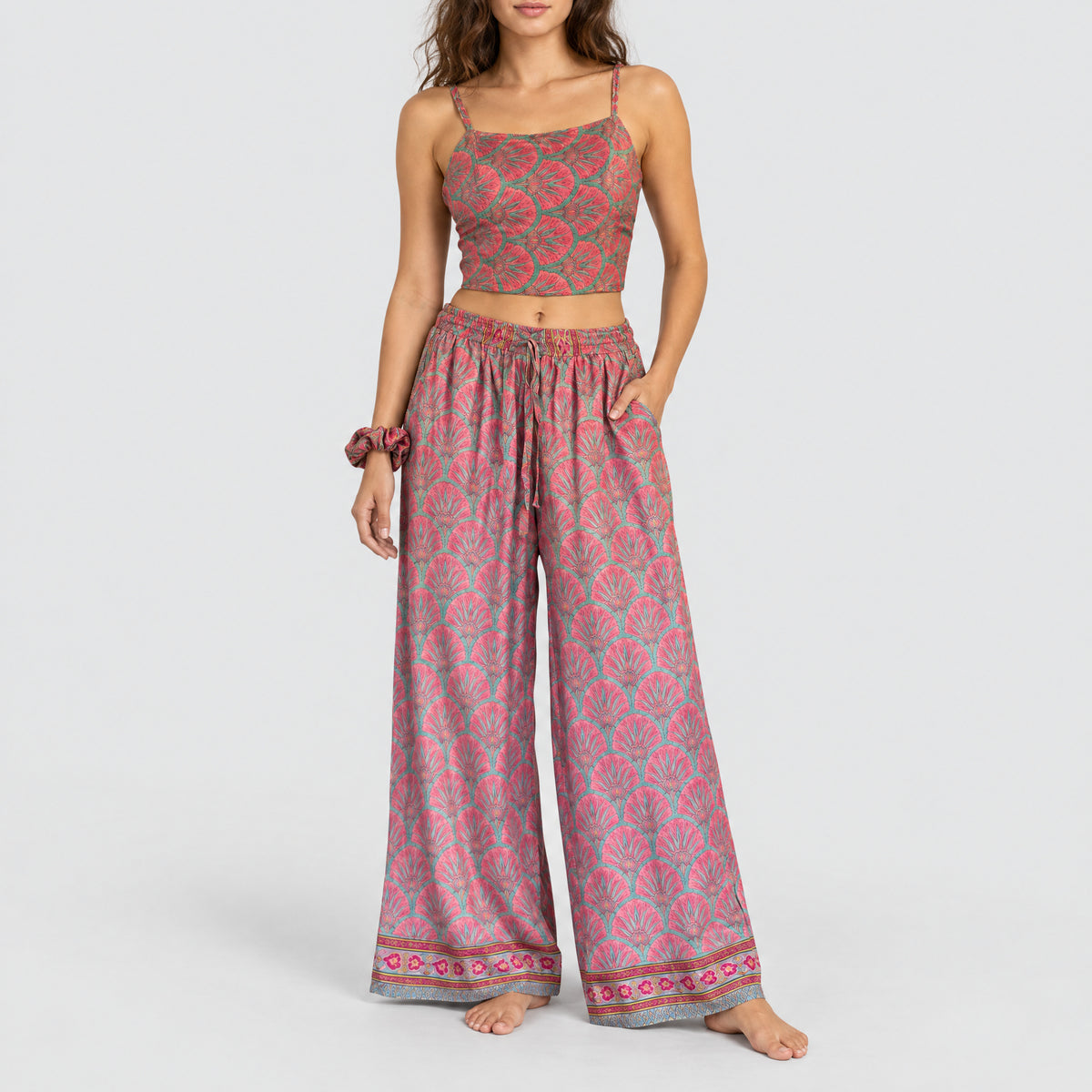 Model trägt Upcycled Set aus Wickeltop und Palazzo-Hose aus Sari-Stoff in Rosa & Türkis