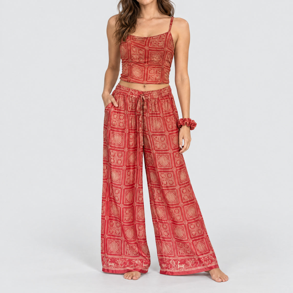 Model trägt Upcycled Set aus Wickeltop und Palazzo-Hose aus Sari-Stoff in Rot & Rosa