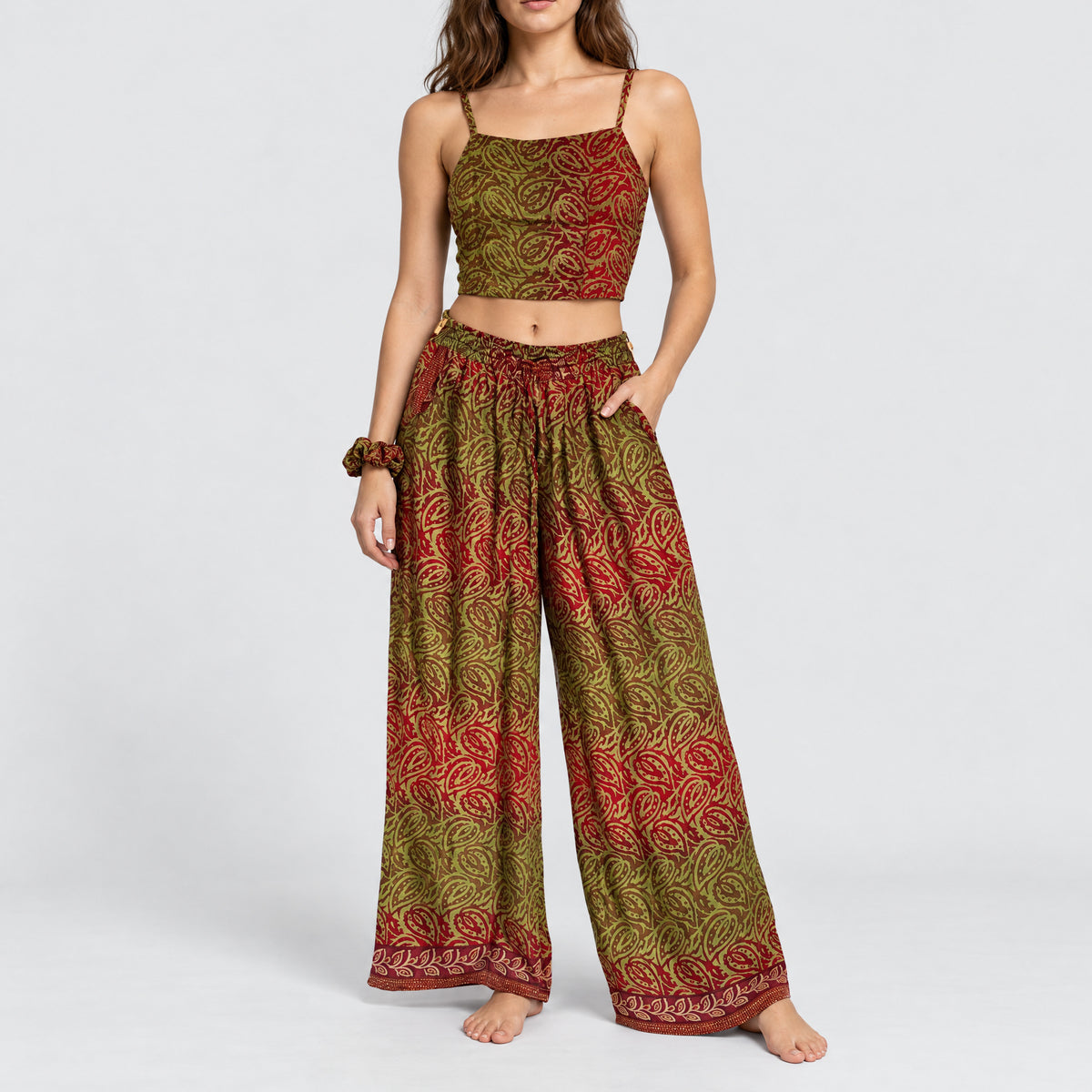 Model trägt Upcycled Set aus Wickeltop und Palazzo-Hose aus Sari-Stoff in Grün & Rosa