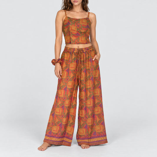 Model trägt Upcycled Set aus Wickeltop und Palazzo-Hose aus Sari-Stoff in Rot & Grün