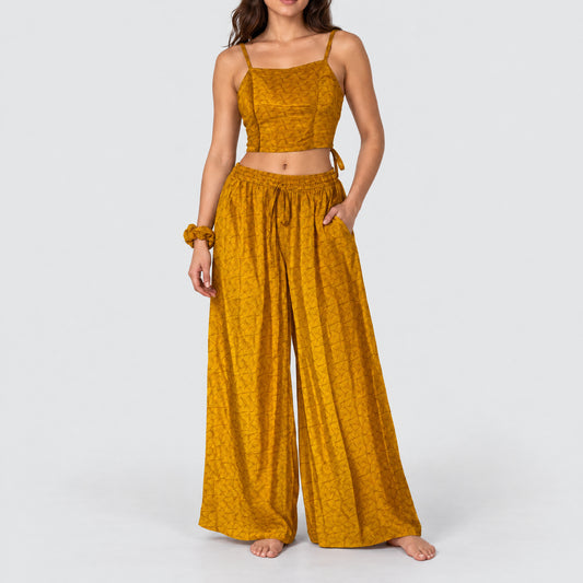 Model trägt Upcycled Set aus Wickeltop und Palazzo-Hose aus Sari-Stoff in Gelb & Orange