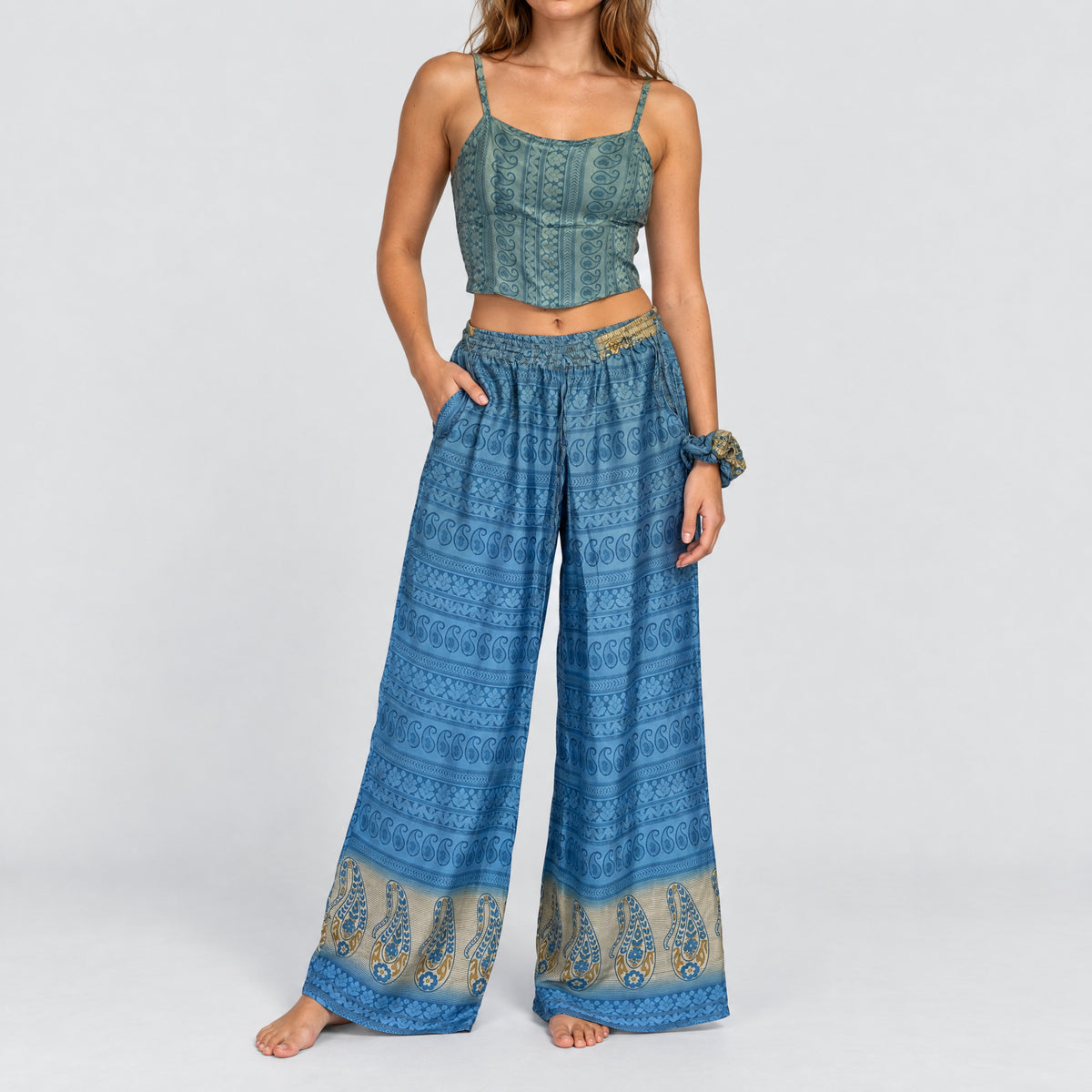 Model trägt Upcycled Set aus Wickeltop und Palazzo-Hose aus Sari-Stoff in Blau & Türkis