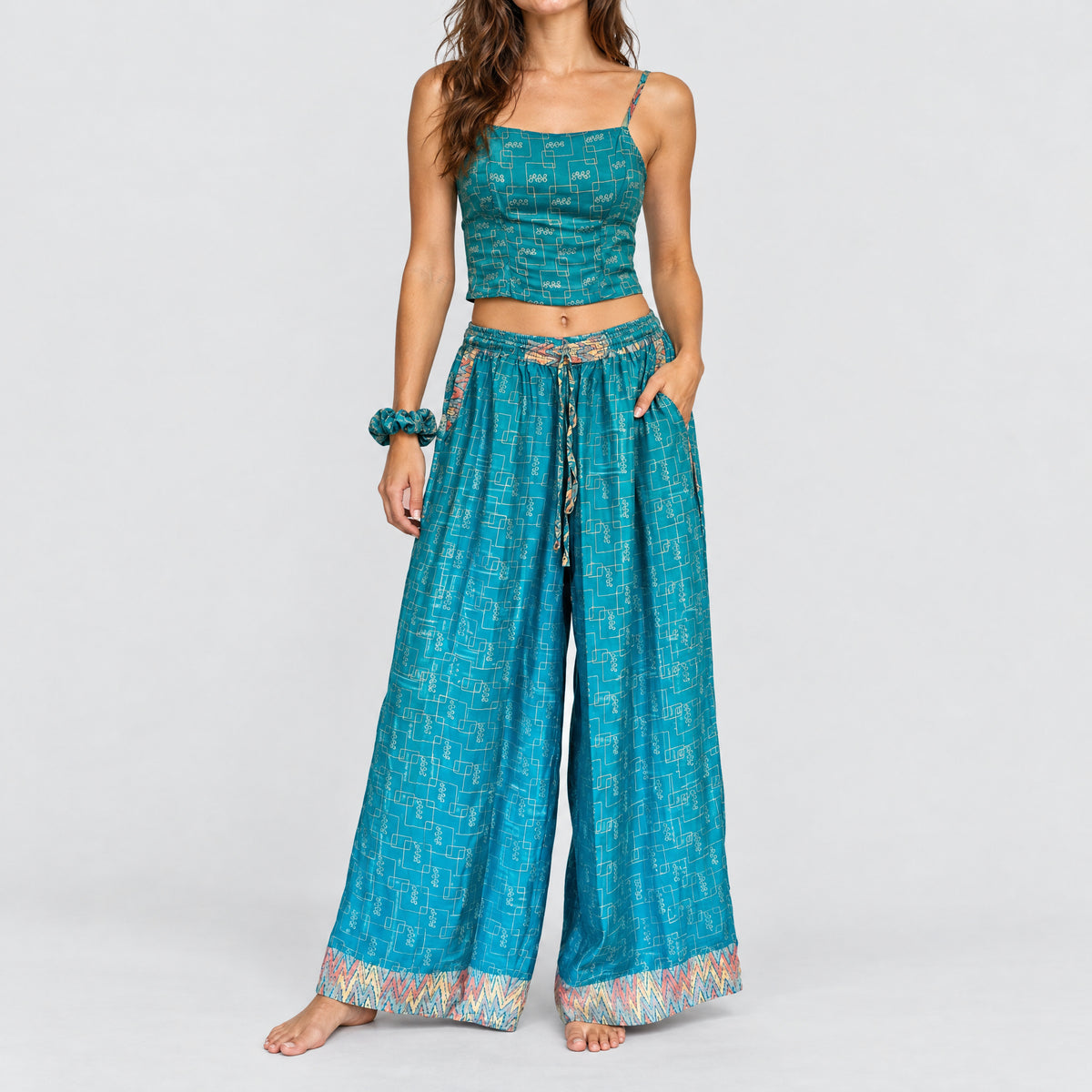 Model trägt Upcycled Set aus Wickeltop und Palazzo-Hose aus Sari-Stoff in Türkis