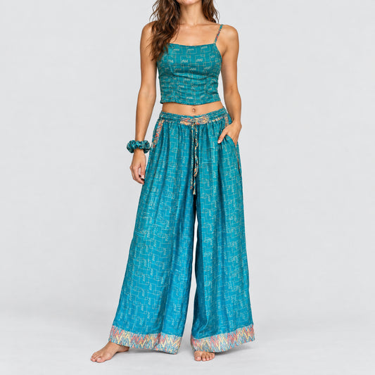 Model trägt Upcycled Set aus Wickeltop und Palazzo-Hose aus Sari-Stoff in Türkis