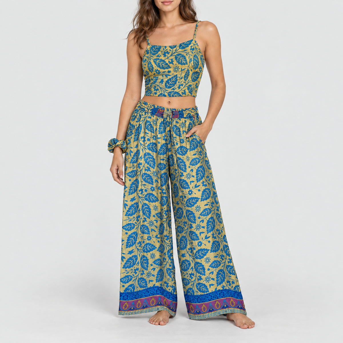 Model trägt Upcycled Set aus Wickeltop und Palazzo-Hose aus Sari-Stoff in Blau & Gold