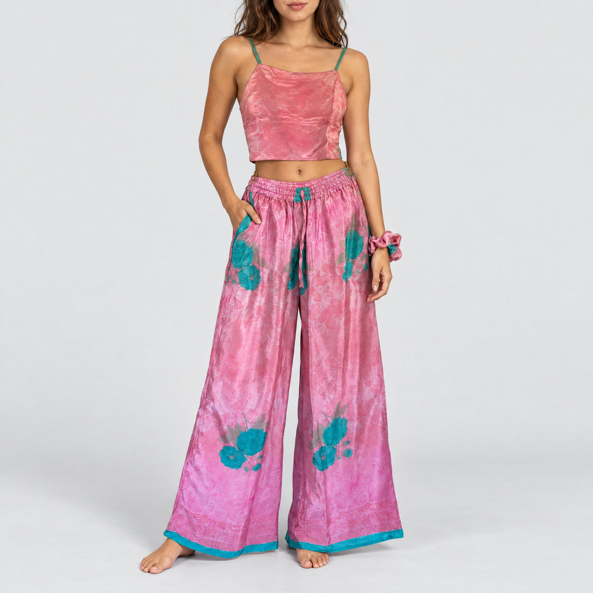 Model trägt Upcycled Set aus Wickeltop und Palazzo-Hose aus Sari-Stoff in Rosa & Türkis
